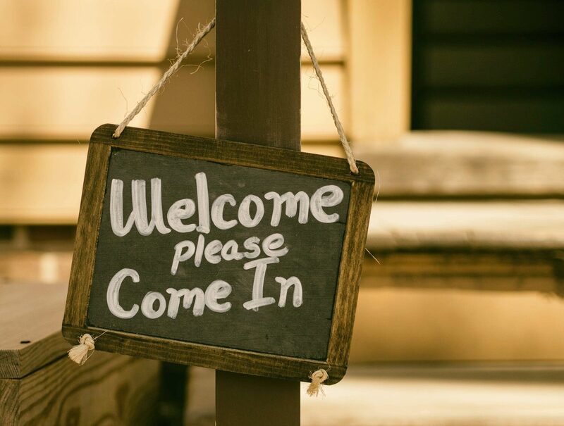 A hand-painted sign reading ‘Welcome, please come in’